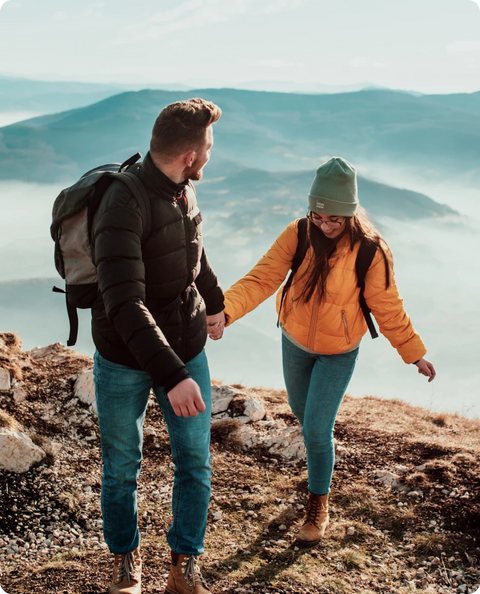 A couple enjoys a scenic hike in the mountains, with mullein gummies in their backpacks for a boost.