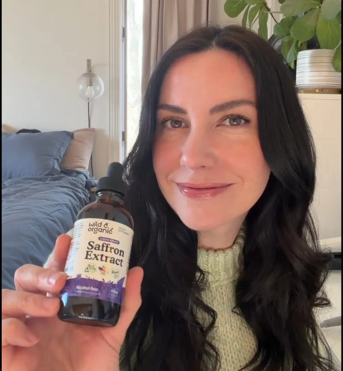 Smiling woman holding the Saffron Extract bottle