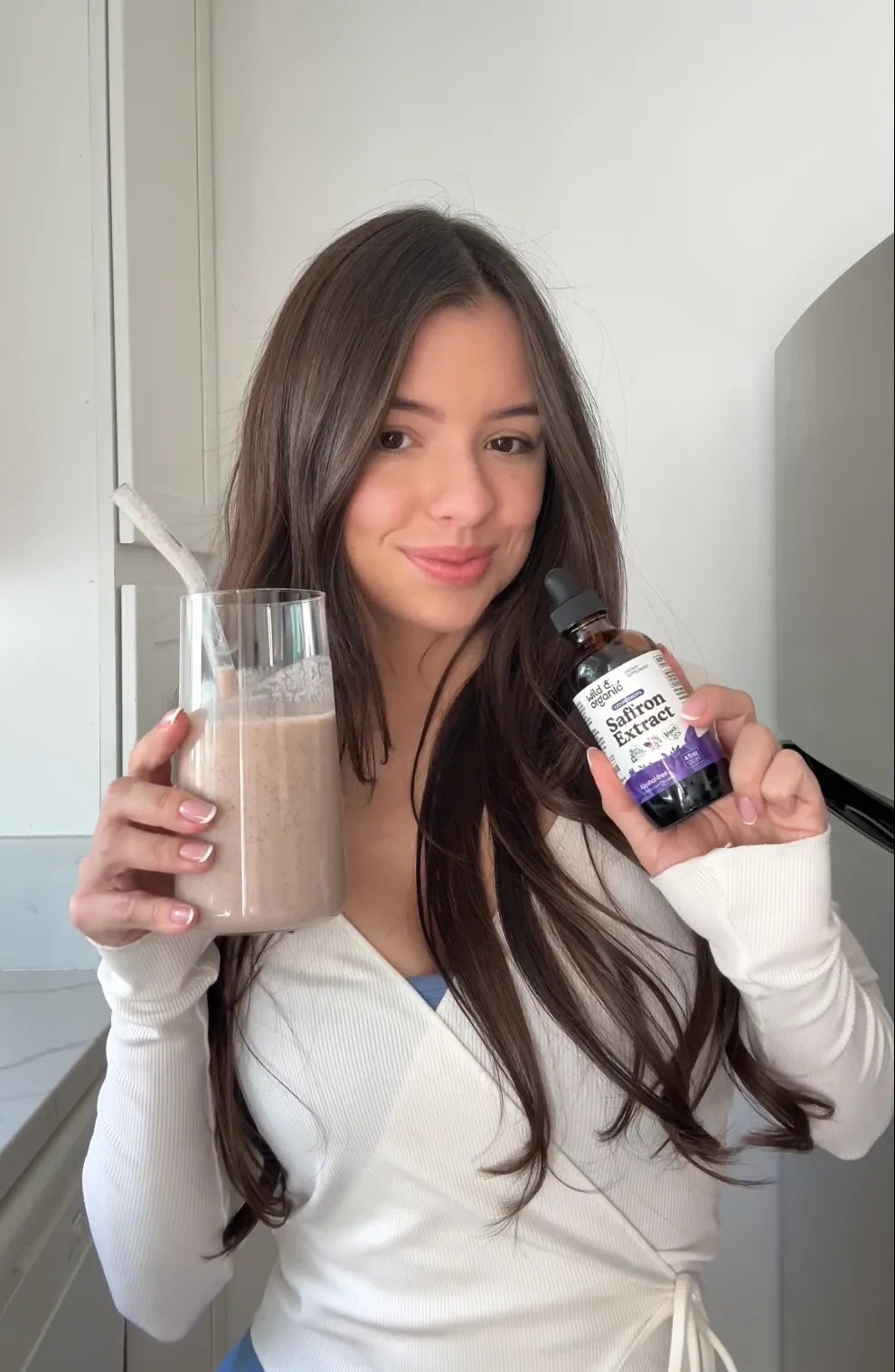 Woman adding Wild & Organic Saffron Extract drops to her morning smoothie